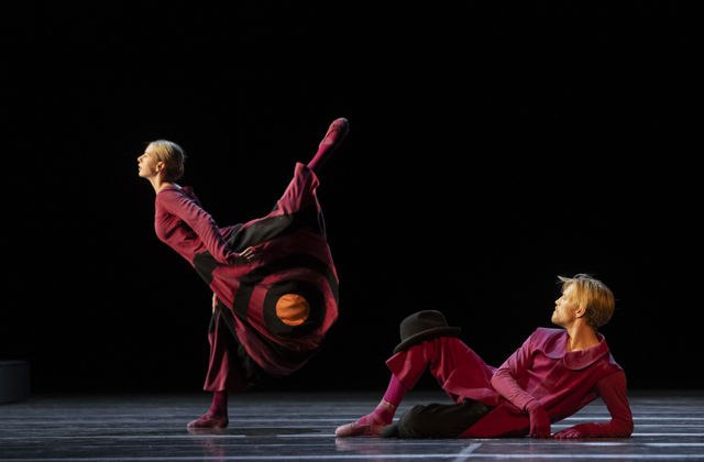 en mann ligger på scenegulvet og ser opp på kvinnelig danser som står i profil
