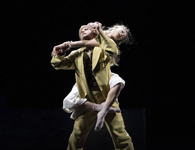 en ung kvinne sitter på ryggen til en mannlig danser 