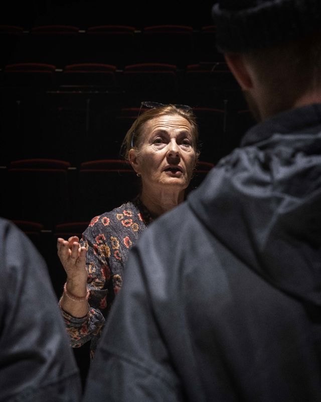 Kvinne i mørkt rom instruerer sanger
