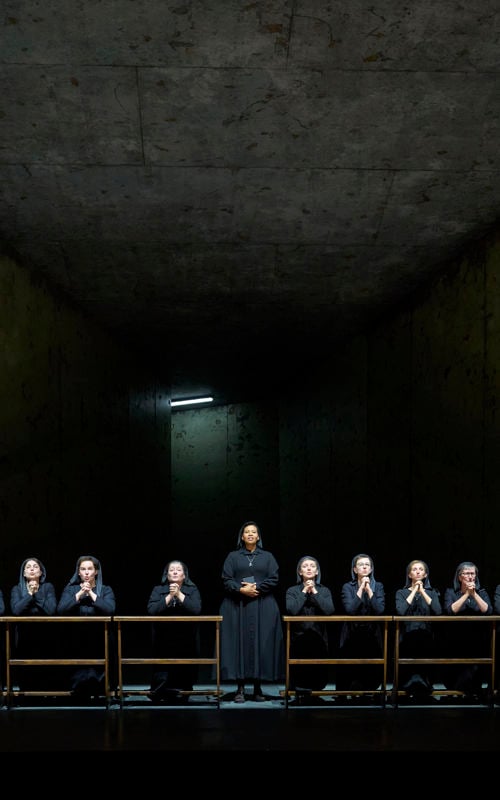 Praying nuns in a dark church