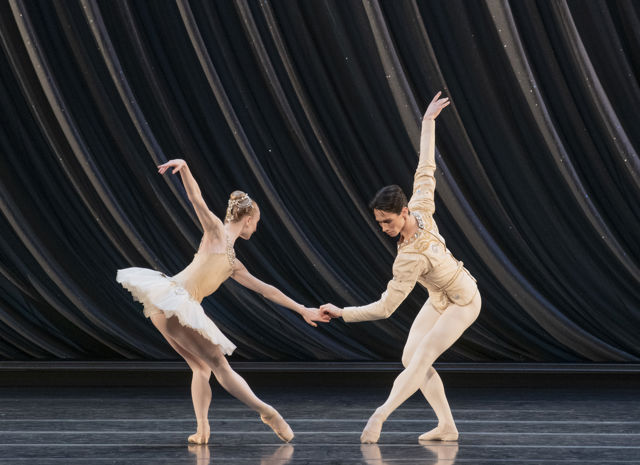 en mann og en dame danser ballett sammen, hun i hvit tutu og tåspissko