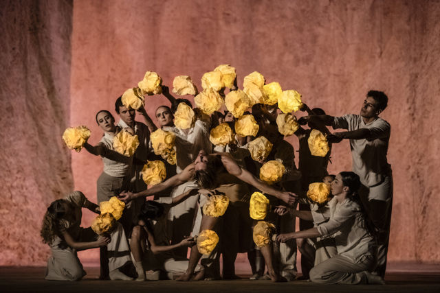 en stor gruppe dansere i dempet belysning med lamper i hendene